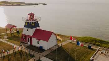 Decorated in the colours of the Acadian flag, Grande-Anse Lighthouse makes for a colourful stop