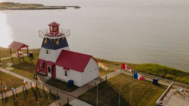 Decorated in the colours of the Acadian flag, Grande-Anse Lighthouse makes for a colourful stop